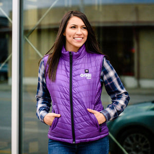 Woman wearing a purple Gobi Heat quilted vest over a plaid shirt