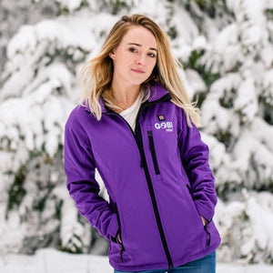 Woman wearing a purple Gobi Heat softshell jacket in a snowy outdoor setting