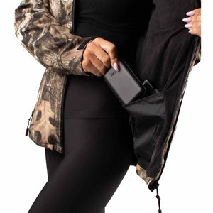 Person placing a black power bank into the interior pocket of a camouflage heated jacket
