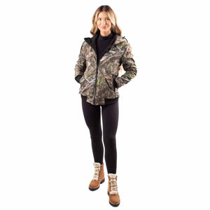 Woman wearing a camo Gobie Heat hooded jacket with black leggings and brown winter boots