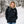 Woman wearing a black Gobi Heat jacket in a snowy forest