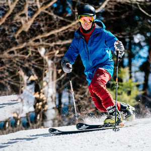 Skier wearing Gordini gloves and blue jacket skiing on a snowy slope
