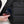 Hand placing a smartphone into the side pocket of a black Got Bag backpack