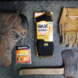 Grabber toe warmers, work boot, Heat Holders socks, leather work gloves, and an axe on a metal surface