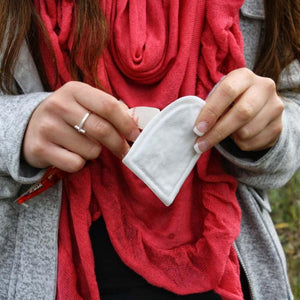 Person holding a white Grabber hand warmer packet