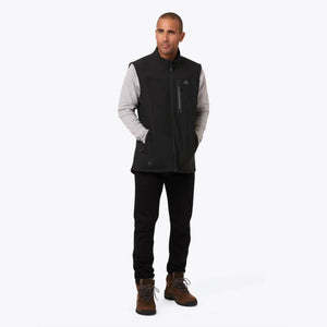 Man wearing a black Mobile Warming heated vest over a grey long sleeve shirt and black pants