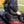 Person sitting on a black Alpcour stadium seat on a metal bleacher