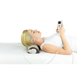 Person using a HealthyLine heated neck pillow with a digital controller while lying down