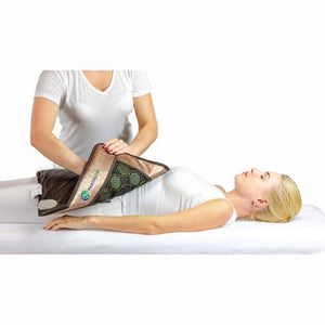 Person placing a HealthyLine gemstone heating mat on a woman lying on a massage table