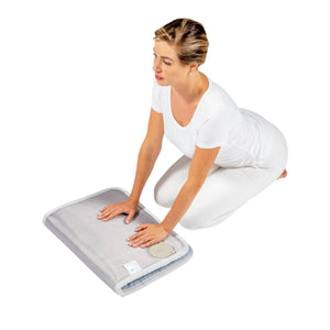 Woman kneeling and placing hands on a HealthyLine heating pad