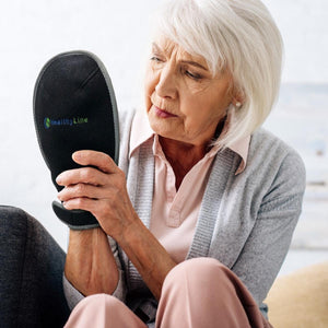 Woman holding a black HealthyLine wrist wrap