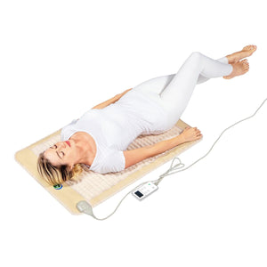 Woman lying on a HealthyLine infrared heating mat with a digital controller