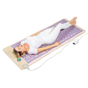 Woman lying on a HealthyLine infrared heating mat with a digital controller