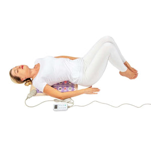 Person lying on a HealthyLine gemstone heating mat with a digital controller