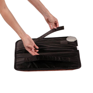 Hands adjusting the velcro strap on a black HealthyLine heating pad