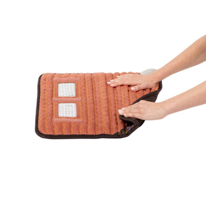 Hands folding a HealthyLine flexible heating pad with visible internal gemstone grid