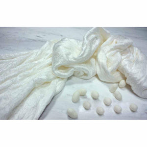 HealthyLine white silk fabric with scattered silk cocoons on a marble surface