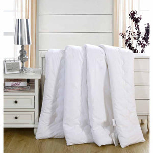 HealthyLine white quilted comforter draped over a white wooden nightstand