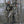 Hunter in camouflage insulated suit aiming a compound bow from a tree stand