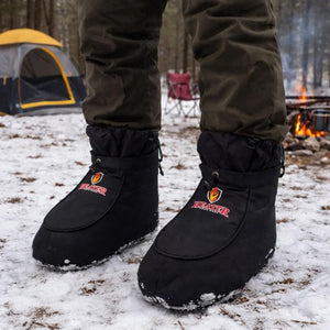 Person wearing black Heater Body Suit insulated booties in a snowy campsite