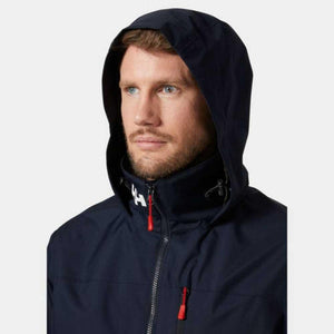 Man wearing a navy blue Helly Hansen hooded jacket with red zipper pulls
