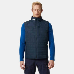 Man wearing a navy Helly Hansen quilted vest over a blue long sleeve shirt