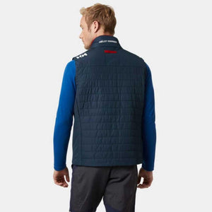 Man wearing a navy Helly Hansen quilted vest over a blue long sleeve shirt
