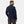Back view of a man wearing a navy Helly Hansen softshell jacket with white branding