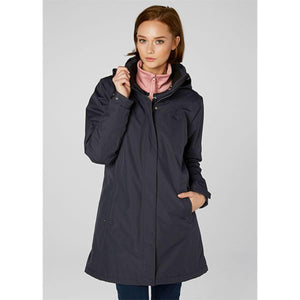 Woman wearing a navy Helly Hansen hooded rain jacket over a pink zip up fleece