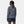 Back view of a woman wearing a Helly Hansen navy and white striped zip neck sweater with navy shorts