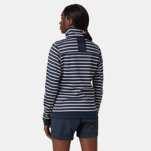 Back view of a woman wearing a Helly Hansen navy and white striped zip neck sweater with navy shorts