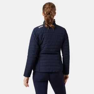 Back view of a woman wearing a navy blue Helly Hansen quilted jacket with HH logo on the shoulder