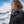 Woman with curly hair wearing a Helly Hansen jacket in a snowy mountain landscape