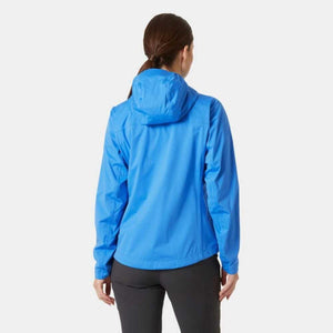 Back view of a woman wearing a blue hooded rain jacket and black trousers