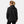 Back view of a woman wearing a black Helly Hansen hooded rain jacket