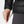 Hand adjusting the adjustable hem drawcord on a black Helly Hansen puffer jacket