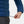 Hand adjusting the hem drawcord on a blue Helly Hansen quilted jacket