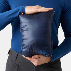 Person holding a packed Helly Hansen navy blue jacket