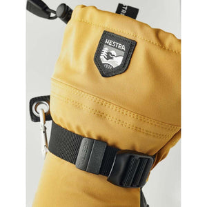 Yellow Hestra mitten with black adjustable wrist strap and Hestra logo patch
