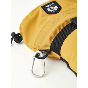 Hestra yellow glove detail with carabiner and brand patch