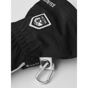 Black Hestra glove with Gore-Tex branding and attached metal carabiner