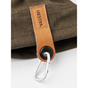 Hestra olive green fabric glove cuff with a leather pull tab and silver carabiner