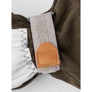 Close up of olive green fabric glove with white leather palm and tan velcro wrist strap