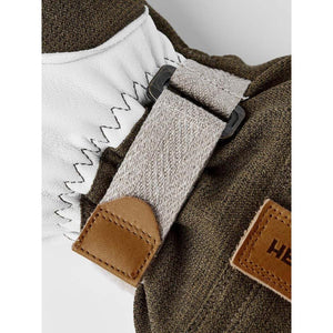 Hestra glove wrist strap detail with white leather and olive green fabric