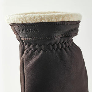 Brown Hestra leather glove cuff with cream shearling lining and zigzag stitching detail
