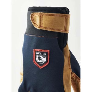 Hestra navy and tan leather glove with velcro wrist strap and brand logo patch