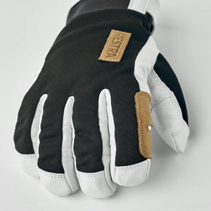 Hestra black and white leather ski glove with tan brand patch