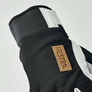 Black and white Hestra glove with leather brand patch