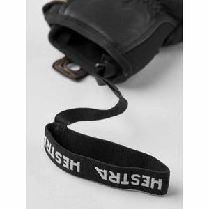 Hestra black glove wrist strap with white logo text
