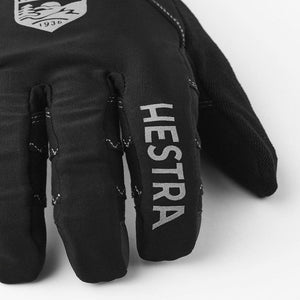 Close up of black Hestra glove with brand logo and text